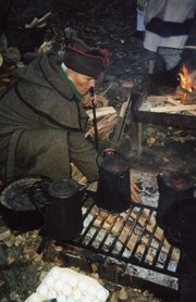 Jim Stanley, of Bonner Springs, cooks over an open fire while re-enacting a portion of the Lewis and Clark expedition. Stanley has been involved in historic re-enactments for more than 30 years and a few years ago participated in a four-year re-enactment.