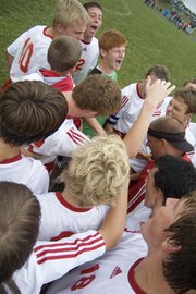 Members of the Tonganoxie High boys soccer team celebrate moments after getting their first win of the season, a 1-0 victory over Perry-Lecompton.