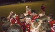 Members of the Tonganoxie High boys soccer team celebrate after earning their second win of the season with a 2-1 regional playoff victory on Oct. 25 at Perry-Lecompton.