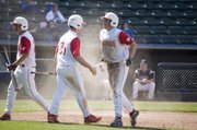 Shane Levy congratulates Dylan Puhr after Puhr slid home to score Tonganoxie's ninth run of the game against Holton in the top of the sixth inning Thursday afternoon at CommunityAmerica Ballpark in Kansas City, Kan. Holton came back to win the game, 10-9.