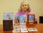 Edie Ommerman sits with urns containing her dogs, Koda and Kong. Ommerman said she still talks to them, at times saying hello when she calls her answering machine to leave herself a reminder while away.