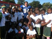 Matt Acree, a 2010 Mill Valley High School graduate and current Drake University football player, is surrounded by Tanzanian youths after playing in the first American football game on the African continent in May.