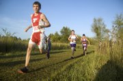 The Chieftains' Jeff Neal glances at the runners ahead of him as he rounds a turn Tuesday at the Tonganoxie Invitational. With a 18th-place finish, Neal was one of six THS boys to medal as Tonganoxie won the team title.