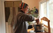 Natalya Lowther, Lawrence stirs some soup on a hot plate as she thinks in bulk and uses little l tricks to make money last longer. In making soup she buys bulk lentils and uses a butternut squash to make a delightful mellow and hearty soup.