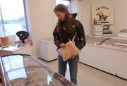 Hillary Urich, Shawnee, selects frozen meat to purchase at Dodge City Beef in downtown Shawnee. Urich said she likes supporting family farms and knowing where her food comes from.