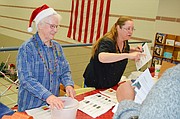 Shawnee Community Services founder Evelyn VanKemseke, left, and volunteer Susan Colston greet children and hand out drawing tickets during the organization's 29th annual Children's Christmas Party Saturday afternoon at the Shawnee Civic Centre. About 500 children and parents attended the free event.