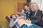 Top photo: Cathy Gordon of Shawnee, far right, gives her daughter-in-law, Emma Gordon, a look at her unborn baby via a sonogram as Emma’s husband, Matt Gordon, and their daughter, Hadley Gordon, gleefully look on at New Birth Company, Johnson County’s only midwife-led birth center.