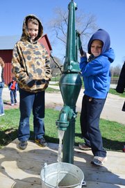 Colin Schuster, right, pumps water from a cistern at the Shawnee Town 1929 Truck Farm as fellow third-grader Hunter Brennan looks on during a Friday morning field trip to the site by Our Lady of the Presentation Catholic School students in Lee's Summit, Mo.