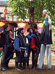 Claire Gurley chats with some of the other performers just after the opening cannon Sunday at the Kansas City Renaissance Festival. Claire will walk the festival grounds on her stilts a few times each weekend this season.
