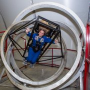 Monica Maurer uses the Multi-Axis Trainer, which simulates the disorientation one would feel in a tumble spin during reentry into the earth's atmosphere.