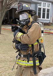 A Shawnee firefighter carries Harley, one of the family's two cats from the house. Harley was inside the burning home for at least 90 minutes.