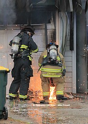 Overland Park firefighters use a saw to remove the home's garage doors.