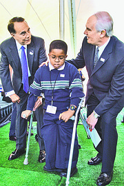 Former Sen. Bob Dole, R-Kansas, left, Mickey McCahan, 7, and Jim Williams, president of Easter Seals, pose for a photo in Washington, D.C., at a Sprint Campaign to collect wireless phones to be recycled and resold to benefit people with disabilities in April 2002. Mickey, of Bowie, Md., is an Easter Seals Ambassador.