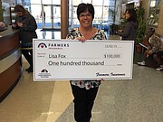 Lisa Fox, a longtime kindergarten teacher at St. Joseph Catholic School, holds up the oversized check she received Wednesday along with the announcement that her proposal had won the school a $100,000 from Farmers Insurance's Thank America’s Teachers Dream Big Teacher Challenge. The funding will go toward providing one iPad for every student.