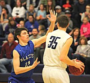 Mill Valley senior Clayton Holmberg (35) surveys the floor while being guarded by Gardner-Edgerton's Bryson Rohr.