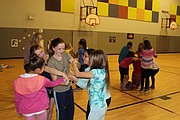 Members of the Bluejacket-Flint Girls on the Run team try to untangle themselves from a hand-holding knot at their Thursday practice. The team combines physical activities with lessons about self-confidence, emotions and respect for others. "Sometimes it's hard to know what emotions we are feeling because our emotions are in a big knot just like the game we played," coach Tiffany DeBoe told the team.