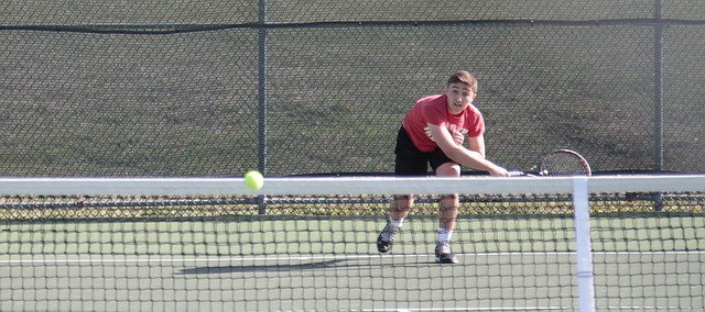 Shawnee Mission North senior Anthony Giambalvo returns a forehand shot just over the net against Blue Valley West's Alec Mills in the Indians first competition of the season Monday at BV West.