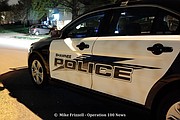 Shawnee Police Sergeant Matt Seichepine checks his computer at the scene of a shooting early Sunday morning.
