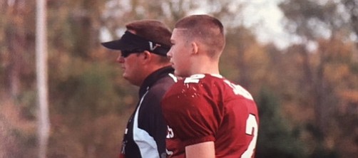 Shawnee Mission North quarterback Will Schneider (right) talks to his father, Marty Schneider) during a youth football game when he was growing up. Will is wrapping up his senior year as the SM North quarterback — 30 years after his father was under center for the Indians.