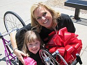 Wiebrecht poses with Emily Paro, of Shawnee, after presenting her with an adaptable bike in 2013. Emily’s family often volunteers for Variety events.