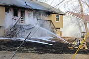 Shawnee Firefighters work to extinguish a hot spot on the rear of the duplex.