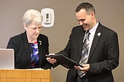 De Soto city clerk Lana McPherson presents Powell with his award at the March 26 council meeting