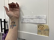 Artwork by a young Hannah Gee is displayed at the new Wizard of Paws. Monica Gee has a tattoo thet replicates the youthful artwork of her daughter, who now is her business partner.