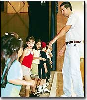 At a rehearsal last Saturday, Tony Valenzuela instructs children in
a folk dance native to the city of Vera Cruz, Mexico. The 5- to
8-year-old children and a troupe of teenage dancers will perform at
Saturday's De Soto Cinco de Mayo festival.