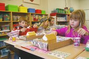 Second-graders in Jessica Jandl's class learned Monday what it's
like to be pastry architects. Decorating gingerbread houses was one
of many holiday events in the district Monday and Tuesday.