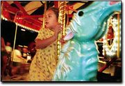 Samantha Martinez, 4, scans the crowd for her parents as she takes
a whirl on the carousal at the annual CPA picnic.