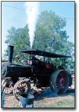 The old Rumely filled the sky with steam Sunday morning as it
powered the sawmill. The engine is now owned by B.J. and Charlotte
Robinson, McLouth, and was originally owned by Herman Watson,
founder of the threshing bee.