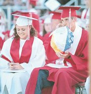 Heather Beach and Brad Bray prepare for the celebration at the end
of graduation ceremonies. Numerous graduates brought party supplies
such as silly string and horns to mark the occasion.