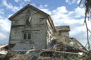 This century-old home at the corner of 198th Street and Woodend
Road received heavy damage from Sunday afternoon's tornado. The
home's occupants, the family of Helen and Duane Newton, took
shelter in the basement. The Newtons had only resided in the home
for a week at the time of the tornado.