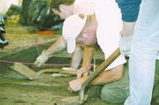 Trever Murawski, wearing a white cap, and Toby Blake scrape away
dirt at the site of a prehistoric house near Tonganoxie.