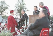 Micah Laundy receives his diploma from school board member Darlyn
Hansen. Also pictured, from left, are Ron Moore, Mike Bogart and
Phil Weide.