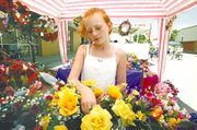 Hillary Chauvin arranges a bouquet of yellow roses in her
grandmother's floral booth during Saturday's Tonganoxie Days
festivities. Booths lined three blocks of Fourth Street, and
activities also were going on at the VFW Memorial Park, the
Leavenworth County Fairgrounds, Tonganoxie Elementary School, the
Tonganoxie City Library and the Amanna elan bed and breakfast.
Hillary and her mother watched the booth for Hillary's grandmother.