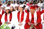 As the last diplomas are handed out to their classmates, Karley
Bennett, Kristi Bishop and John Bretthauer are ready for the
celebration to begin. Many of the graduates came equipped with
disposable cameras and Silly String.