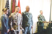 Sgt. Timothy Gustafson, second from left, stands beside Lt. Gen.
Schultz, director of the national guard, while receiving his purple
heart. His wife, Janice, is pictured to his right.