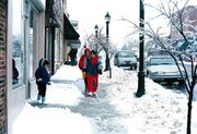Downtown strollers walked carefully last Wednesday on ice-coated
sidewalks. Pictured, center, is Michelle Conroy, followed by her
mother, Pat Conroy. To the left is P.J. Conroy, 7.