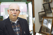 John Lenahan stands near a display of historical photos in his
store, Lenahan Hardware, in Tonganoxie's downtown business
district. Lenahan, who is 83, announced last week his plans to
retire this summer and close his store. The 100-year-old building
has housed a hardware store for the past 50 years.