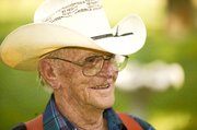 Wearing his trademark red suspenders and plaid shirt, John Smith
relaxes in the shade of his backyard, which is a part of Paul and
Elizabeth McKie's Tailgate Ranch, just south of Tonganoxie.
