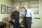 Walter Denholm, 76, left, says he's been "doctoring" with Phil
Stevens "since right after he came to Tongie," and considers Dr.
Phil a good friend as well as a physician. "You bet," said Denholm,
"and if he doesn't know he'll send you to of docs won't do that."
The photos on the wall are of babies Dr. Stevens delivered during
his first eight years of practice.