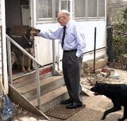 The Stevens household is home base to three dogs and three
"outdoor" cats. Phil Stevens is greeted by dogs Shy Guy, left and
Sonny.