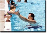 David Rawls encourages his daughter, Megan, 2, to jump in during a
day outing to the Tonganoxie swimming pool. The local pool is
celebrating its 75th birthday this year.