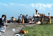 Friends, relatives and emergency workers made a joint effort Sunday
afternoon to begin cleaning up in the rural housing development at
166th Street and Kansas Avenue. The house in the background was
flattened by what has been ranked as an F2 tornado. The tornado
destroyed four homes in the development.