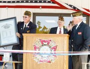 Larry Meadows, post commander of VFW Post 9271, holds the new copy
of the VFW's charter. Jefferson Lawson, state commander of Kansas
VFW, presented the charter to the group during Saturday morning's
dedication of the new post home. The building's construction, which
began two years ago, was recently completed.